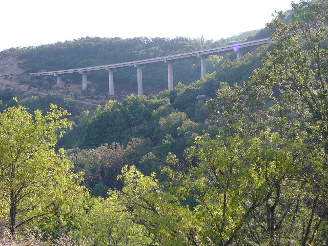 Autoroute en surplomb. Après un plateau, le paysage devient plus vallonné.